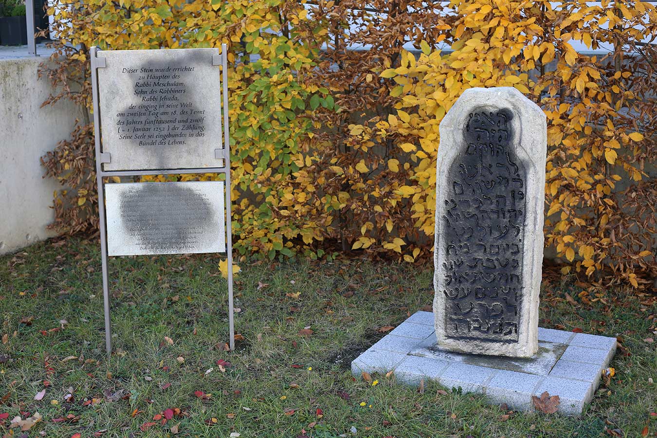 Jüdischer Grabstein mit dazugehöriger Erklärungstafel großflächig mit schwarzer Farbe besprüht