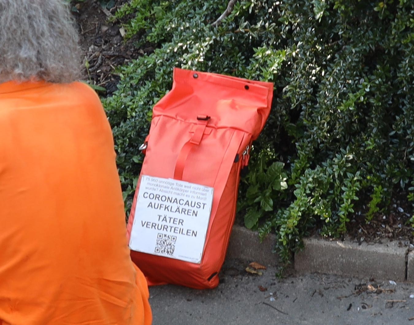 Schild mit der Aufschrift »CORONACAUST AUFKLÄREN TÄTER VERURTEILEN«